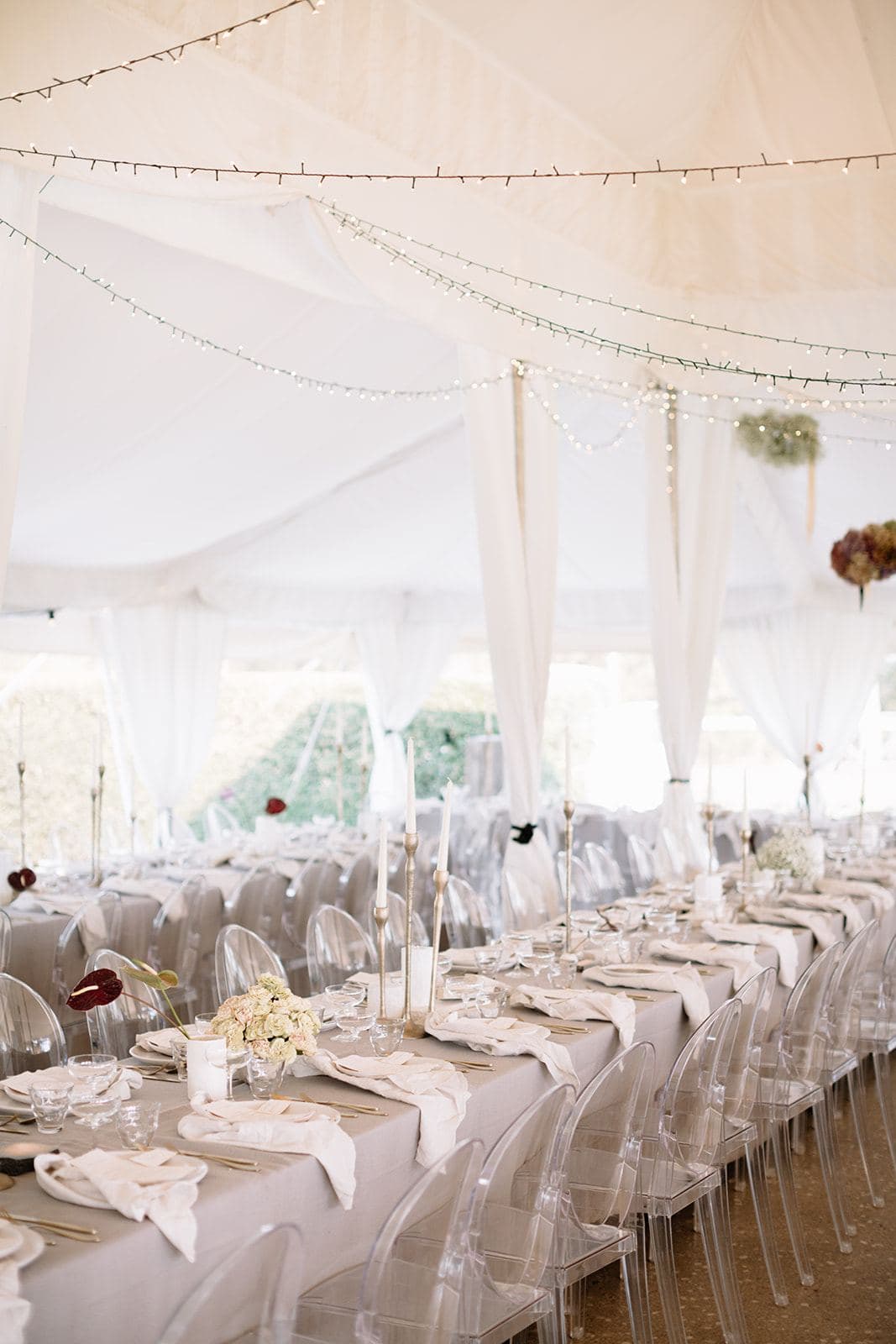 Draped marquee interior with fairy lights over reception tables