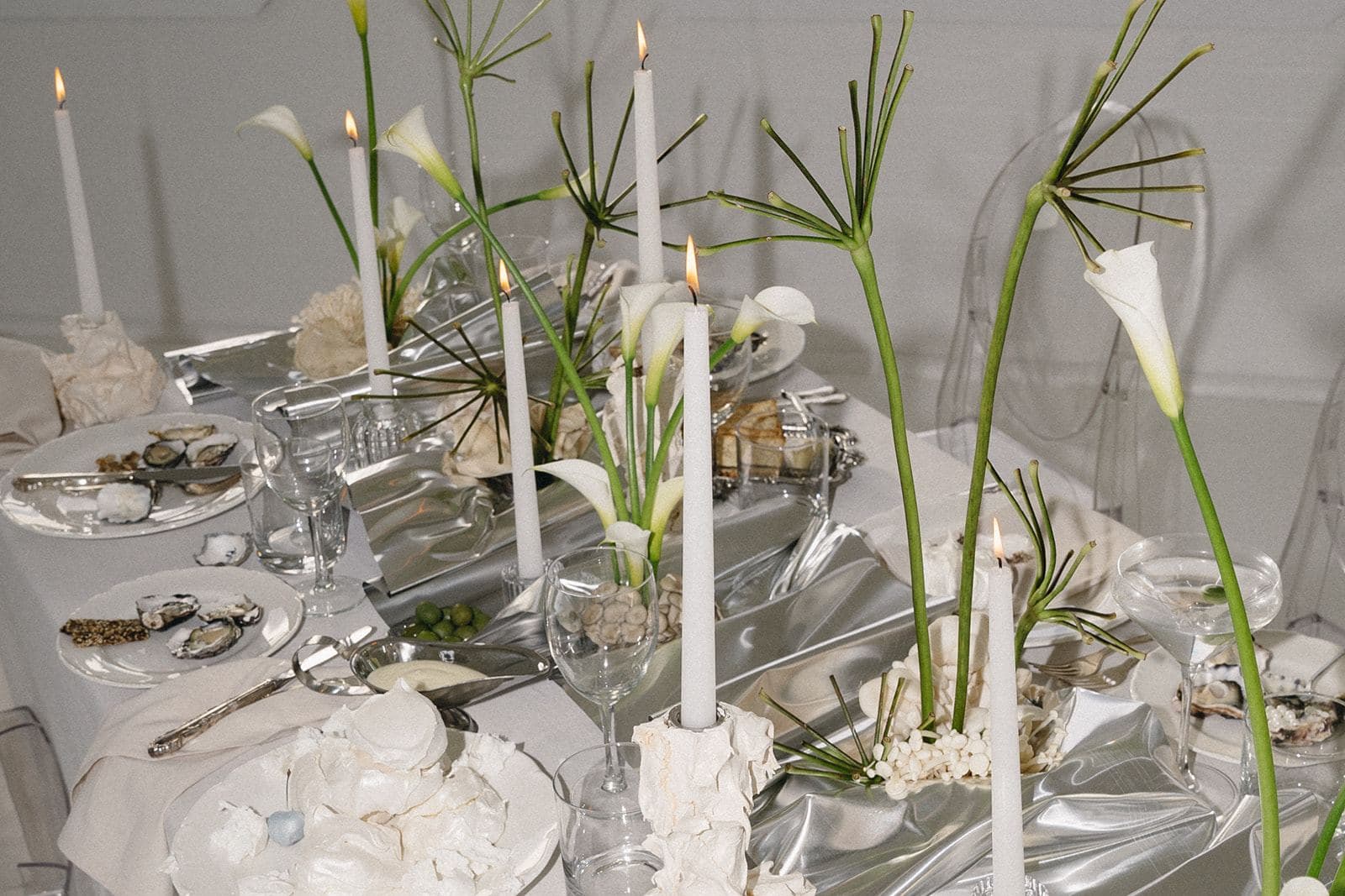 Taper candles, calla lilies and silver styling on a white table